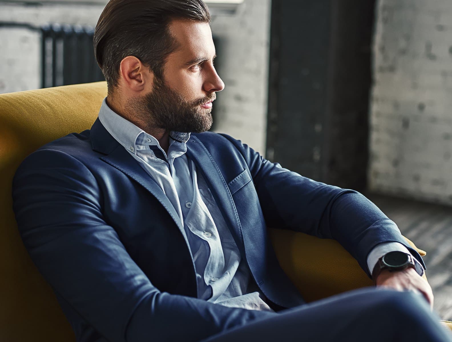 A man seated in a tailored jacket