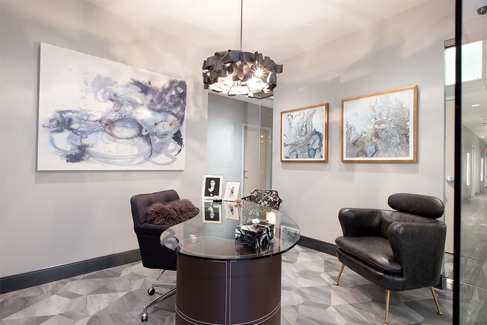 A consultation room with leather chairs and abstract art