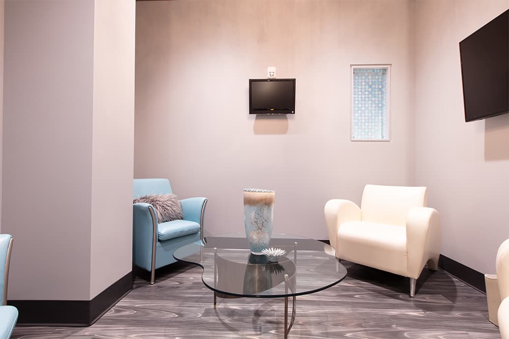 A quiet waiting lounge with blue and cream armchairs
