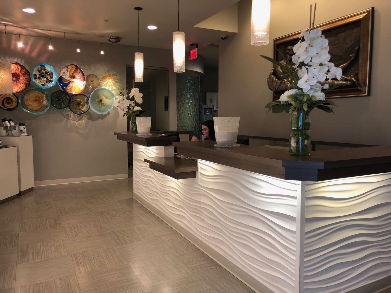 The Wexford front desk, with blown-glass plates along the wall and orchids at reception