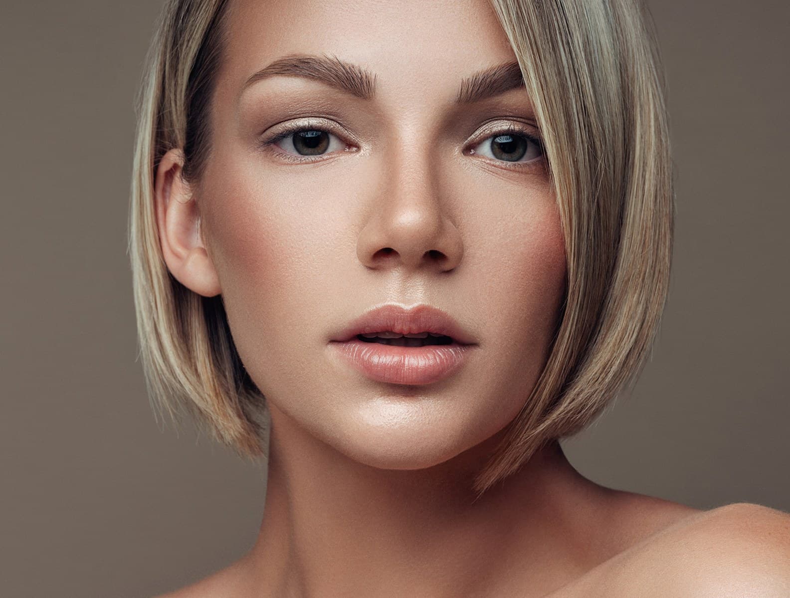 A woman with a blonde bob looking directly at the camera